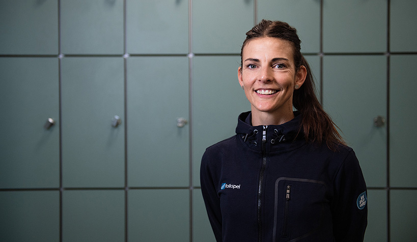 Simhopparen Anna Lindberg framför skåp i omklädningsrum