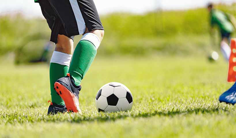 Fotbollsspelare som driver en fotboll