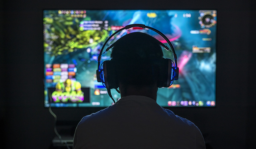 Gamer som spelar datorspel med hörlurar