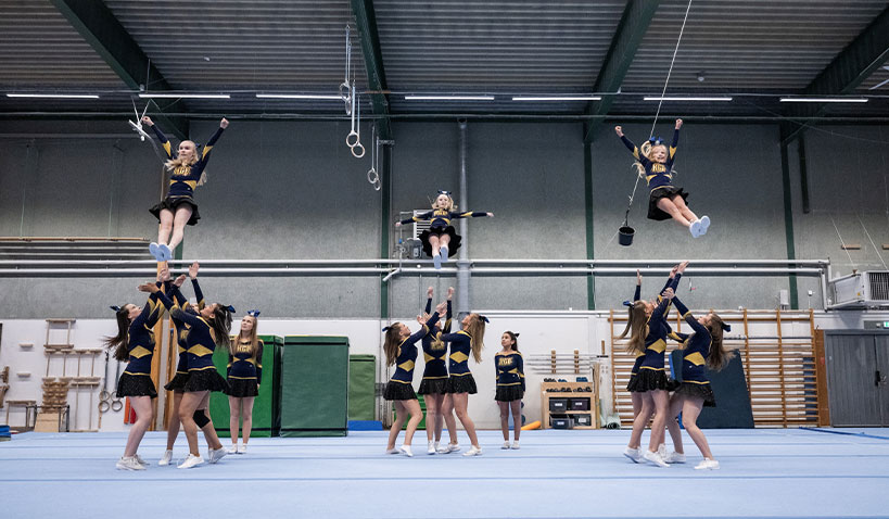 Grupp flickor tränar cheerleading i Halmstads Gymnastikförening