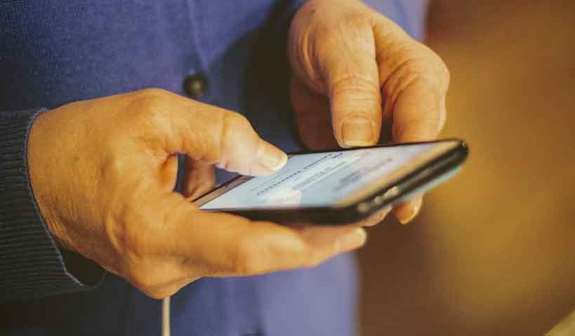 En äldre person som håller i en smartphone