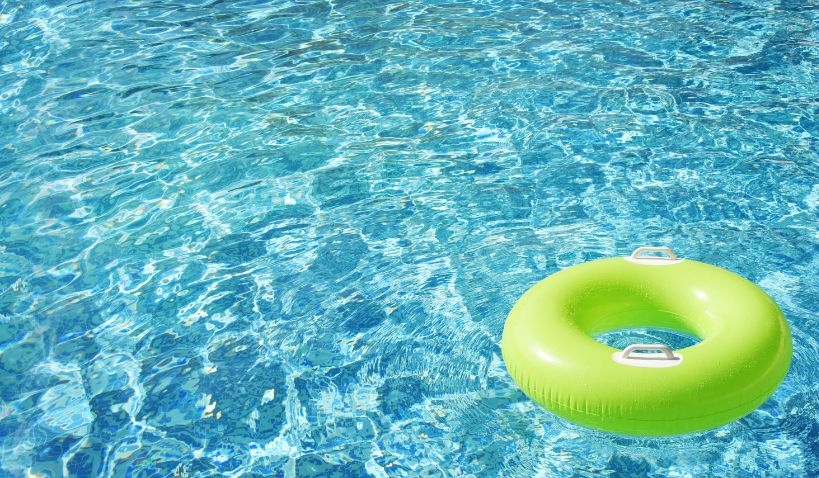 Grön badring flyter i pool