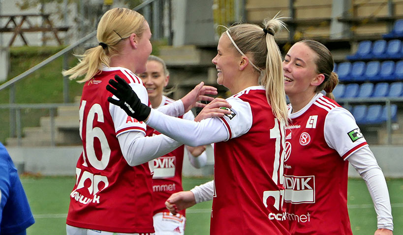 Fyra glada fotbollsspelare i Sandvikens IFs dam- och flickverksamhet som peppar varandra under match 