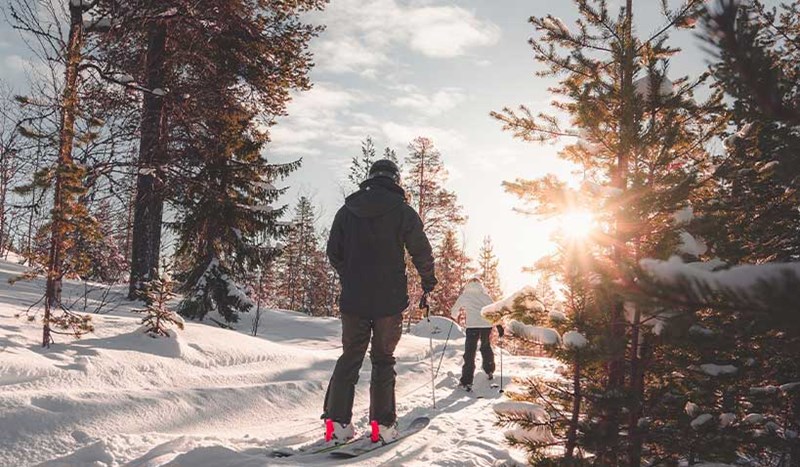 Skidåkare i skidspår i soligt väder.
