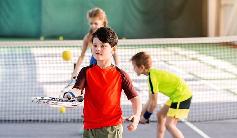 Pojkar som spelar tennis.