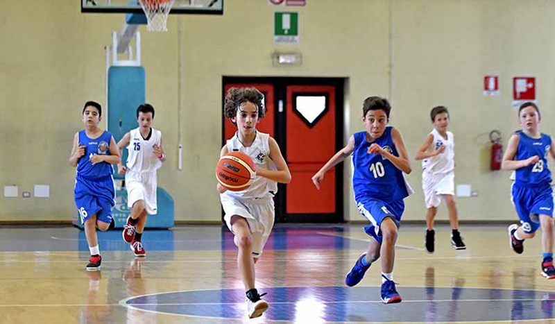 Ungdomar spelar basket.