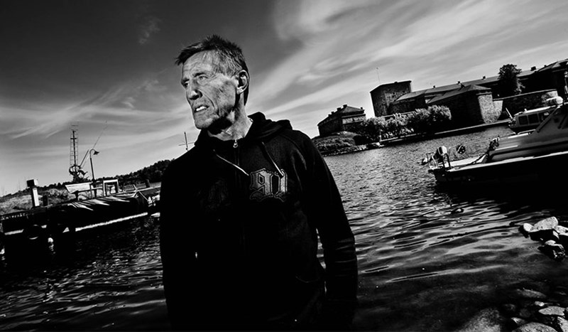 Svartvit bild på Börje Salming med en båthamn i bakgrunden