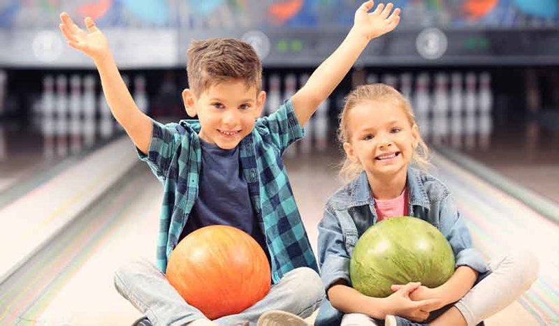 Två glada barn på bowlingbana