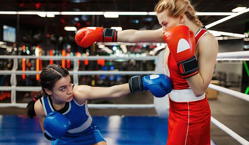 Två tjejer som träningsboxas i en boxningsring