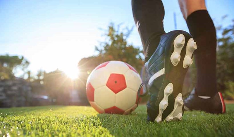 En närbild på person som förbereder sig för att sparka en fotboll