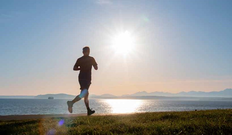 En joggare på strand i solnedgång