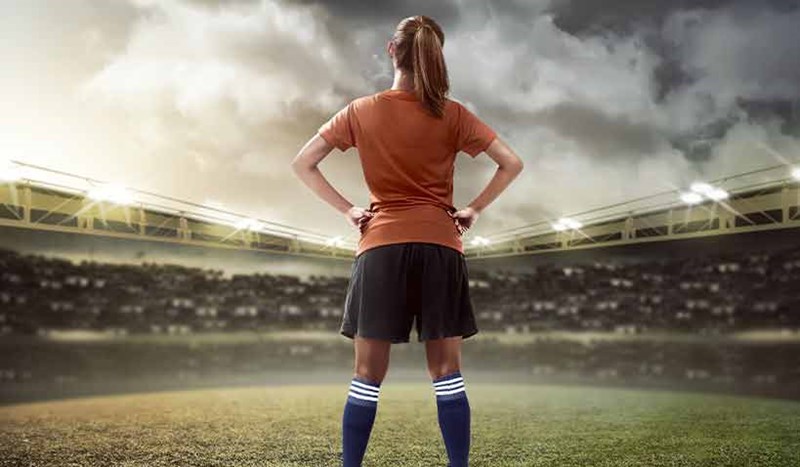 Kvinnlig fotbollsspelare blickar ut över arena
