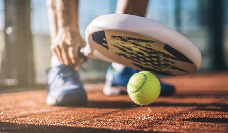 Ett padelracket och en padeltennisboll