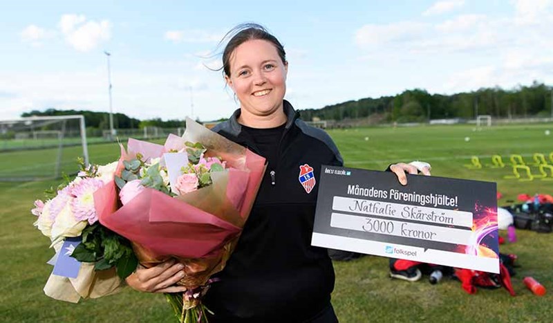 Nathalie Skärstrom tar emot blombukett. Månandens föreningshjälte.