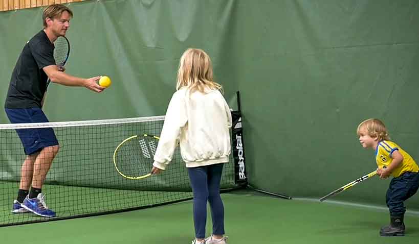 Barn som spelar tennis.