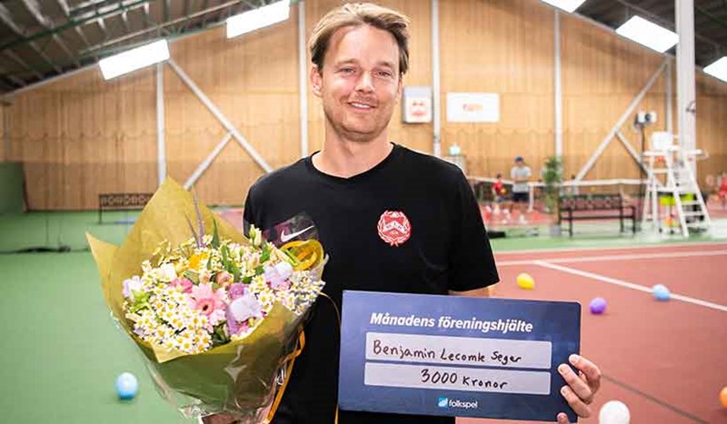 Tennistränare tar emot blommor. Föreningshjälte.