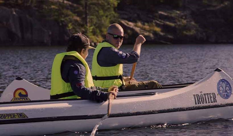 Scouter paddlar kajak i vacker miljö.